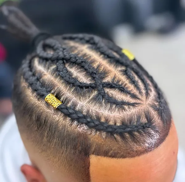 Top-down view of intricate stitch braids in a sculpted pattern with a gold hair cuff